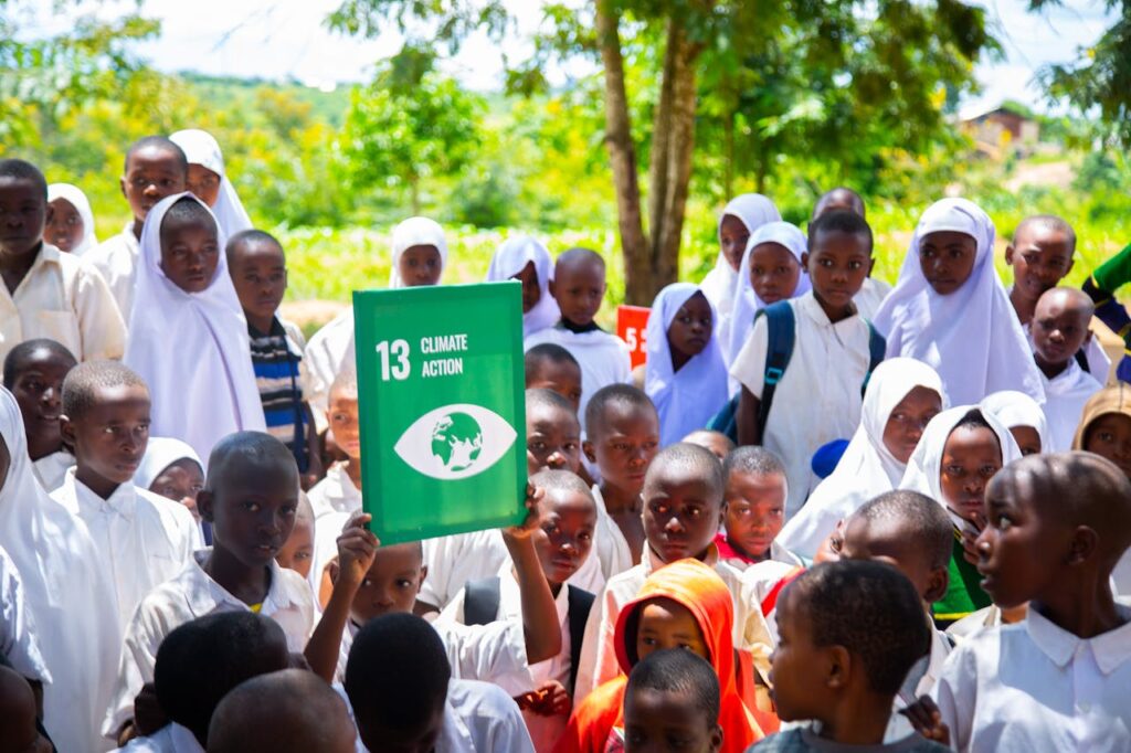 pexels-photo-31748020-2 Group of children holding a Climate Action sign, promoting awareness for sustainable development.